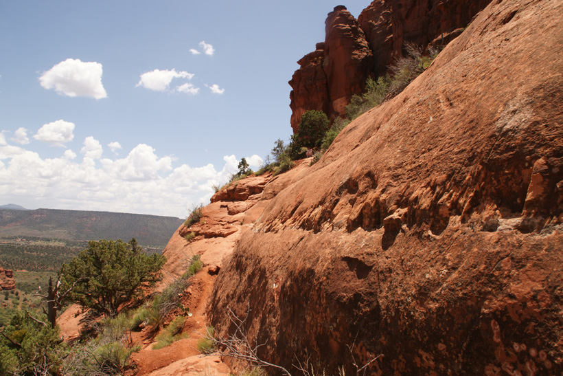 Narrow dirt path leading to a 10 foot rock climb
